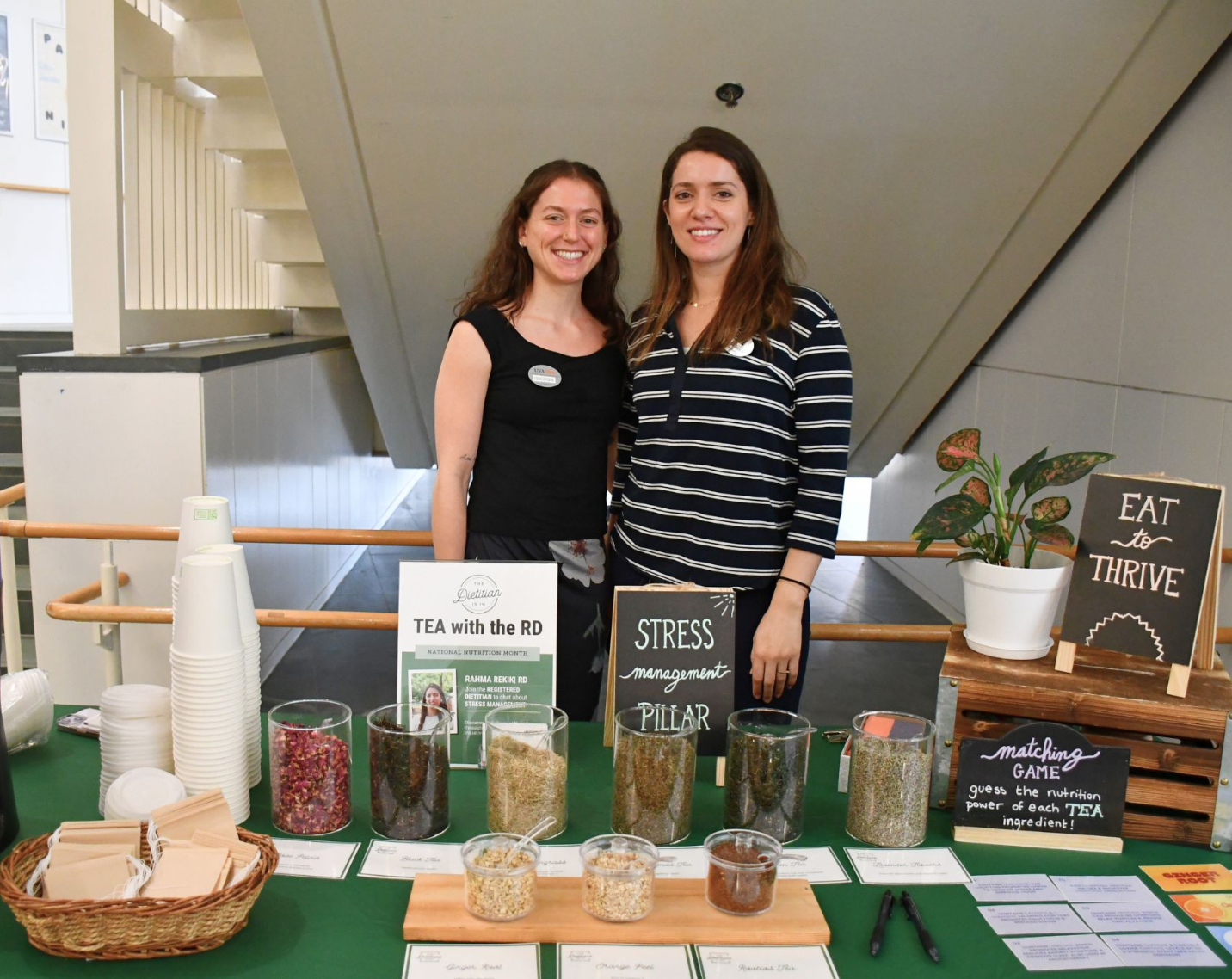 Registered dietitians at the University of Virginia host "Tea with an RD". They stand in front of loose leaf tea on a table with ingredient lists.